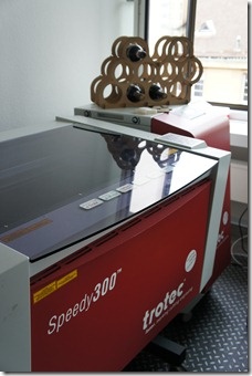 A laser cutter with a laser cut wine bottle holder