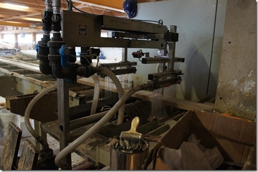 The lengths of wood are sprayed with glue The lengths of wood are sprayed with glue