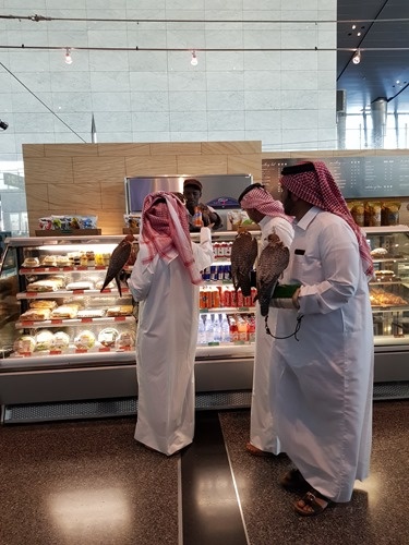 Men with falcons buying snacks