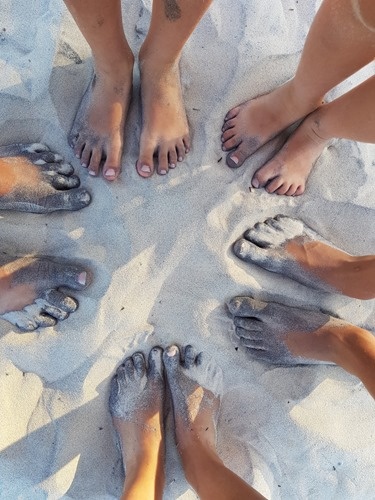 Black and white sand on our feet